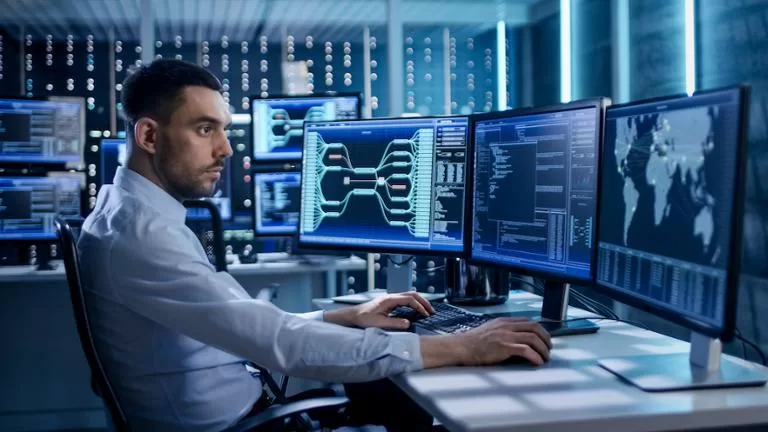 man looking at multiple computer screens